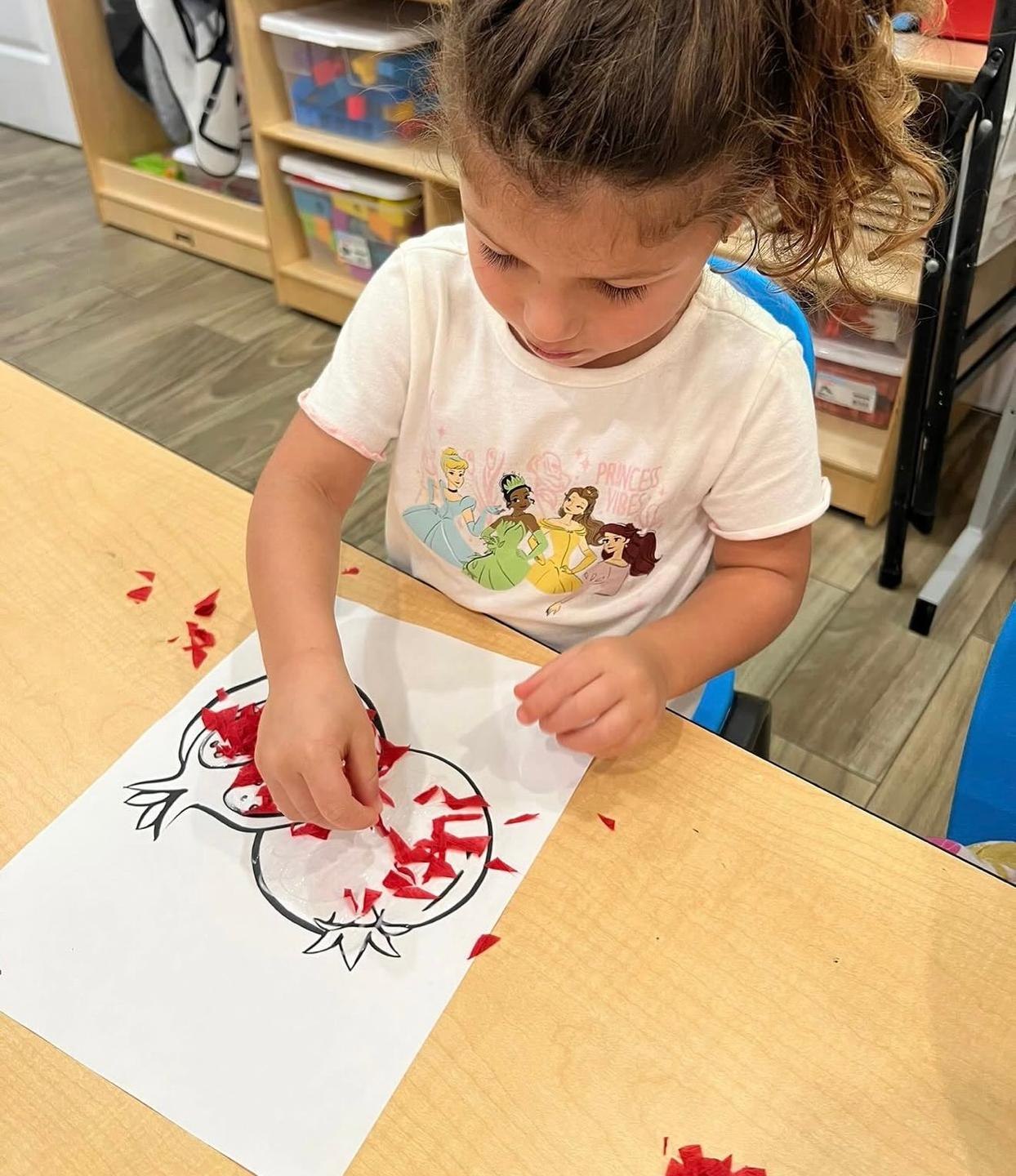 A child working on a pomegranate craft