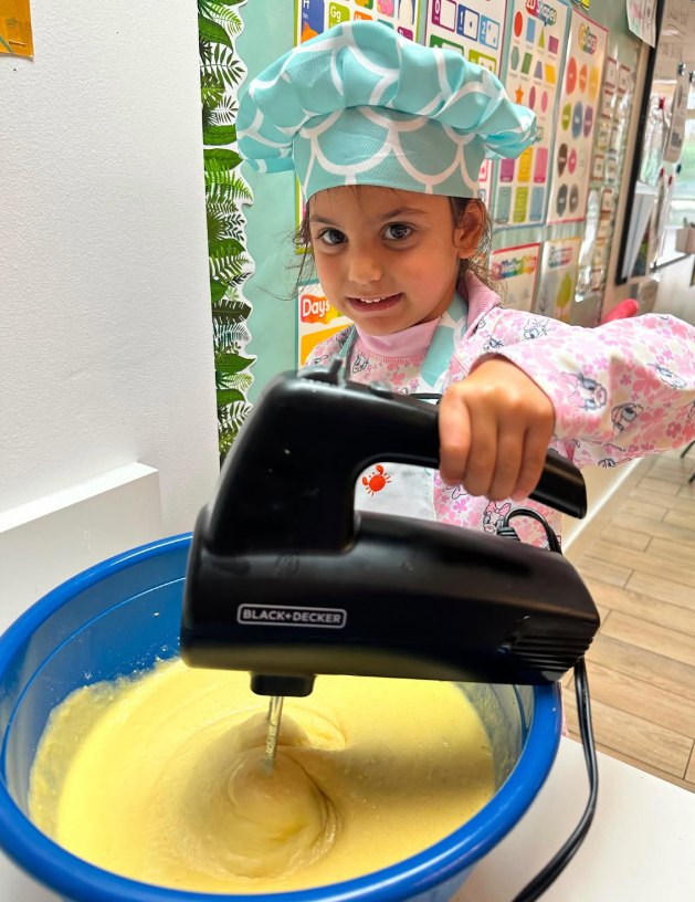 A child mixing batter in the school kitchen
