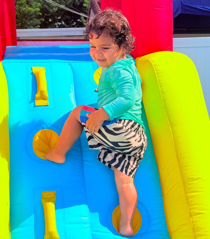 A child on the bounce house at camp