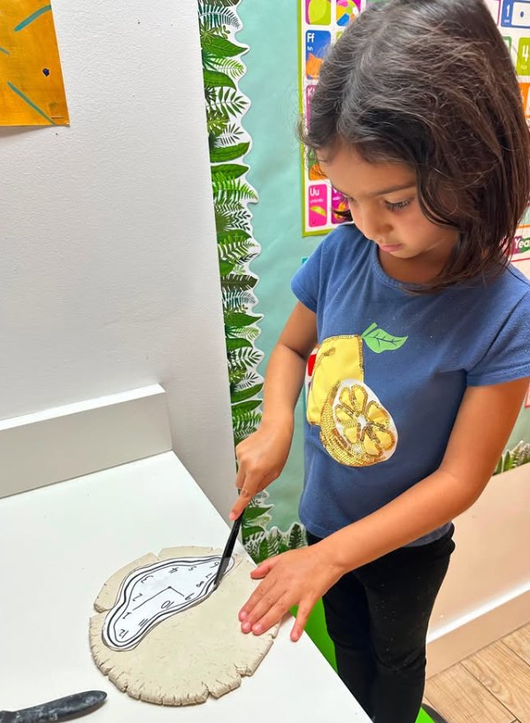 A child taking a tray out of the oven