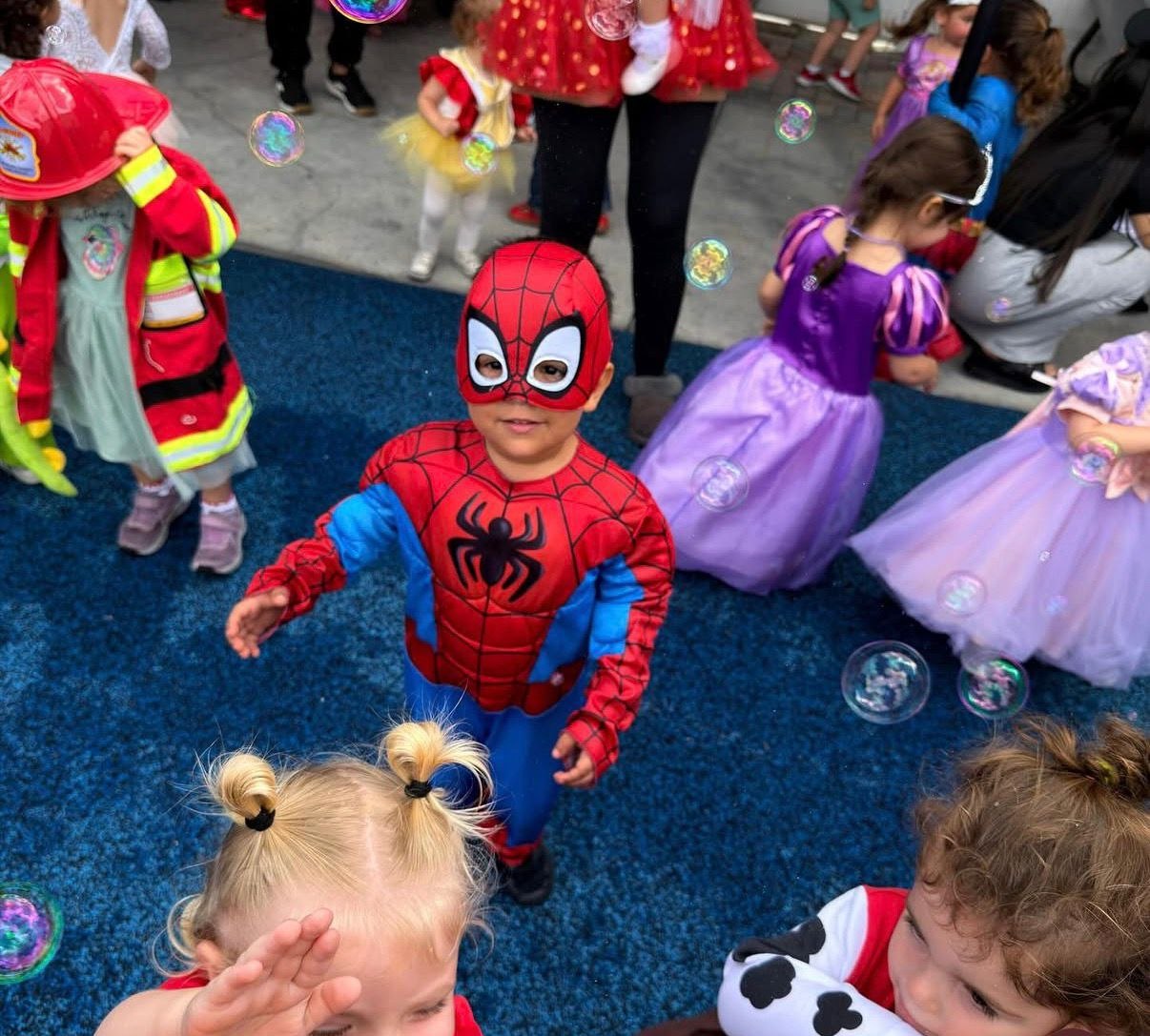 Children in costume playing with bubbles at Learn and Smile