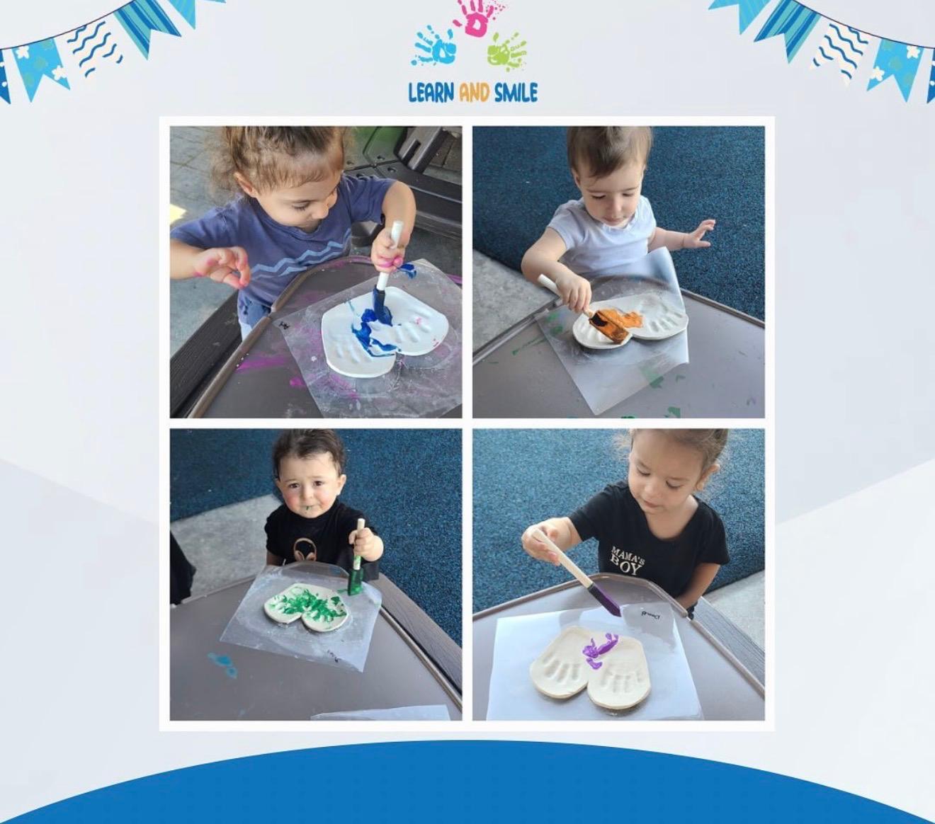 Toddlers painting handprint keepsakes