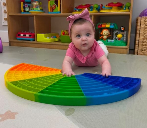 A baby on the play mat in the infant room